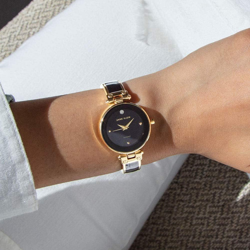 Reloj de pulsera Anne Klein con esfera de diamantes genuinos y diseño elegante en negro y dorado